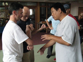 He Jinbao instructing students in the finer details of a cutting binding technique